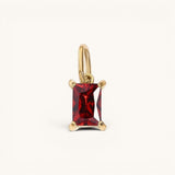 Nadare Co. rectangle birthstone charm featuring a deep red gemstone set in polished gold on a simple bail.