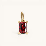 Nadare Co. rectangle birthstone charm featuring a deep red gemstone set in polished gold on a simple bail.