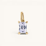 Nadare Co. rectangle birthstone charm featuring a clear emerald-cut crystal set in polished gold.