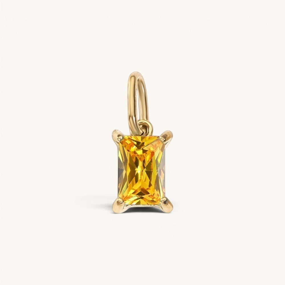 Nadare Co. rectangle birthstone charm featuring a vibrant yellow gemstone set in polished gold on a simple bail.