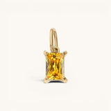 Nadare Co. rectangle birthstone charm featuring a vibrant yellow gemstone set in polished gold on a simple bail.