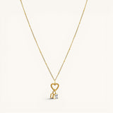 Nadare Co. gold necklace featuring a heart-shaped clasp charm with a dangling rectangle birthstone and letter charm.