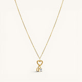 Nadare Co. gold necklace featuring a heart-shaped clasp charm with a dangling rectangle birthstone and letter charm.