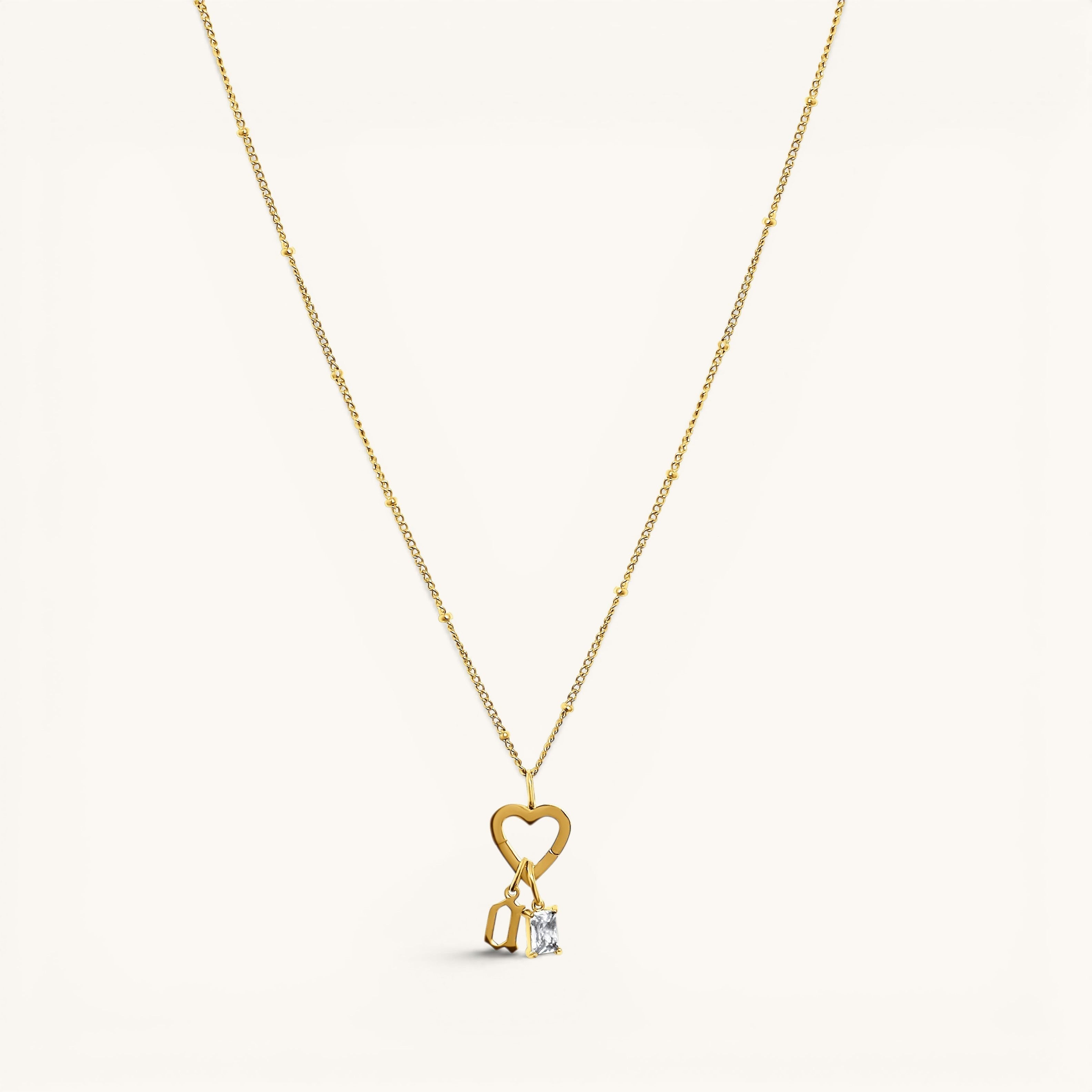 Nadare Co. gold necklace featuring a heart-shaped clasp charm with a dangling rectangle birthstone and letter charm.