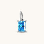 Nadare Co. rectangle birthstone charm featuring a bright blue cubic zirconia stone in a silver-tone setting.