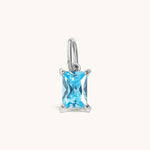 Nadare Co. rectangle birthstone charm featuring a light blue cubic zirconia stone in a silver-toned setting