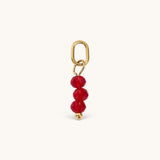 Nadare Co. birth month bead charm featuring three faceted red beads and a gold jump ring for necklace stacking.