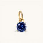 Nadare Co. round birthstone charm featuring a deep blue cubic zirconia stone set in 14k gold plated stainless steel.