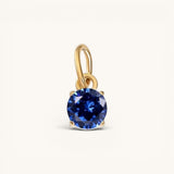Nadare Co. round birthstone charm featuring a deep blue cubic zirconia stone set in 14k gold plated stainless steel.