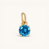 Nadare Co. round birthstone charm in 14k gold plated stainless steel with a bright blue cubic zirconia stone.