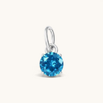 Nadare Co. round birthstone charm featuring a vibrant blue cubic zirconia stone in a silver-tone setting.