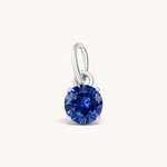 Nadare Co. round blue birthstone charm featuring a sparkling cubic zirconia stone set in polished silver-tone metal.