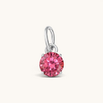 Nadare Co. round birthstone charm featuring a vibrant pink cubic zirconia stone set in polished silver-tone metal.