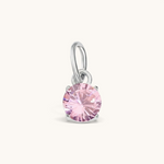 Nadare Co. round birthstone charm featuring a sparkling pink cubic zirconia stone set in a silver-tone metal setting.