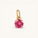Nadare Co. round birthstone charm in 14k gold plated stainless steel with a vibrant pink cubic zirconia stone.