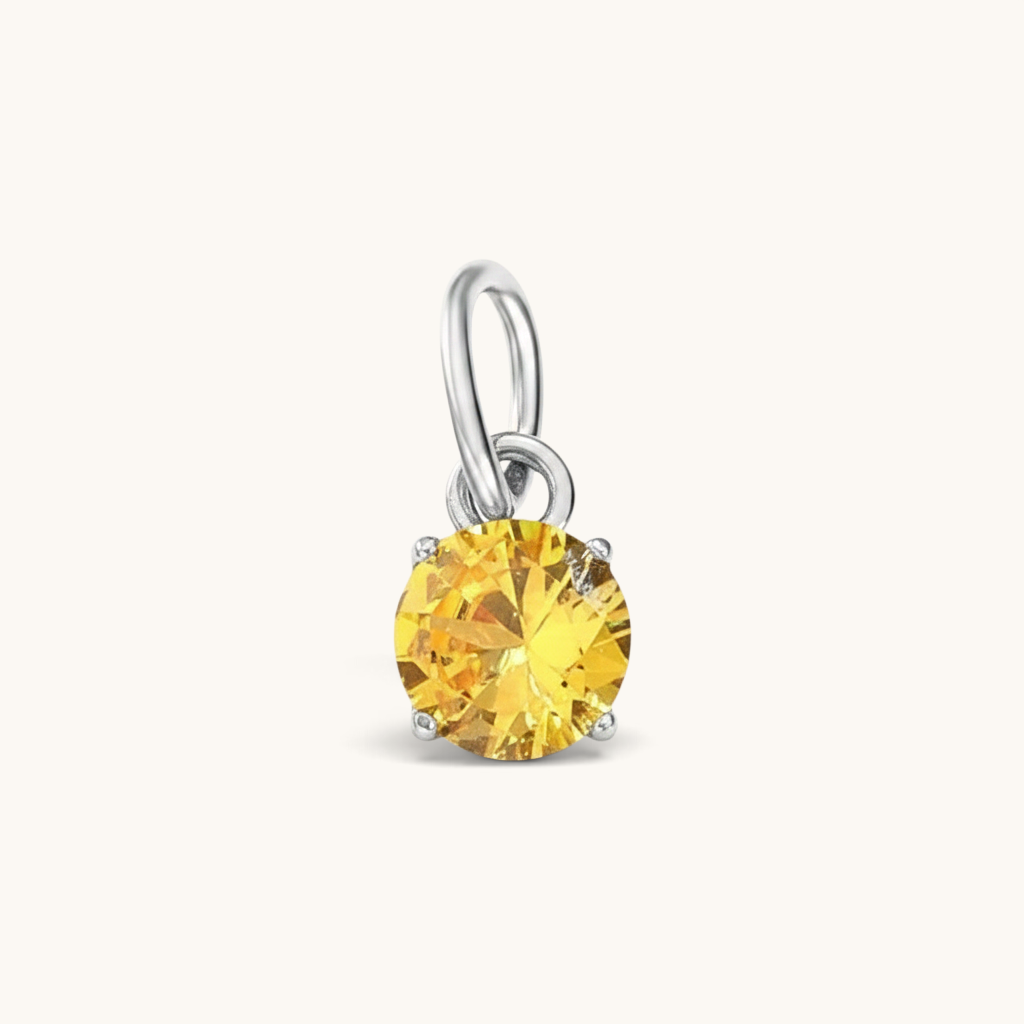 Nadare Co. round birthstone charm featuring a sparkling yellow cubic zirconia stone set in silver-tone metal.