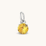 Nadare Co. round birthstone charm featuring a sparkling yellow cubic zirconia stone set in silver-tone metal.
