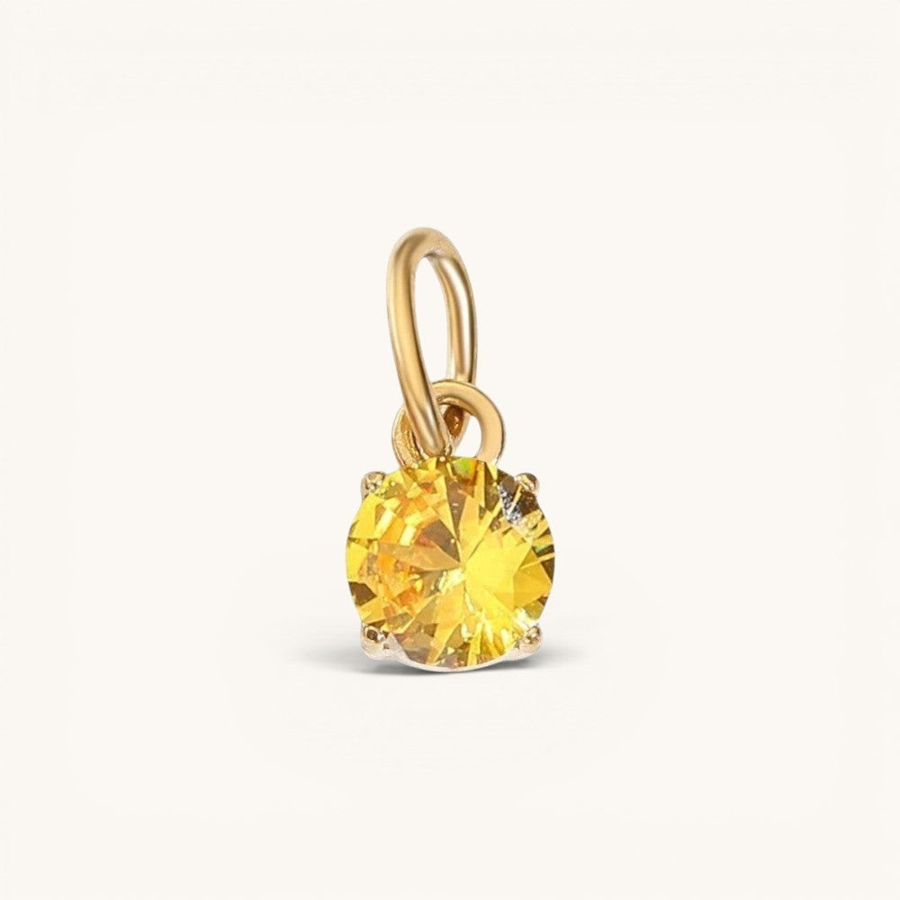 Nadare Co. round birthstone charm featuring a yellow cubic zirconia stone in 14k gold plated stainless steel