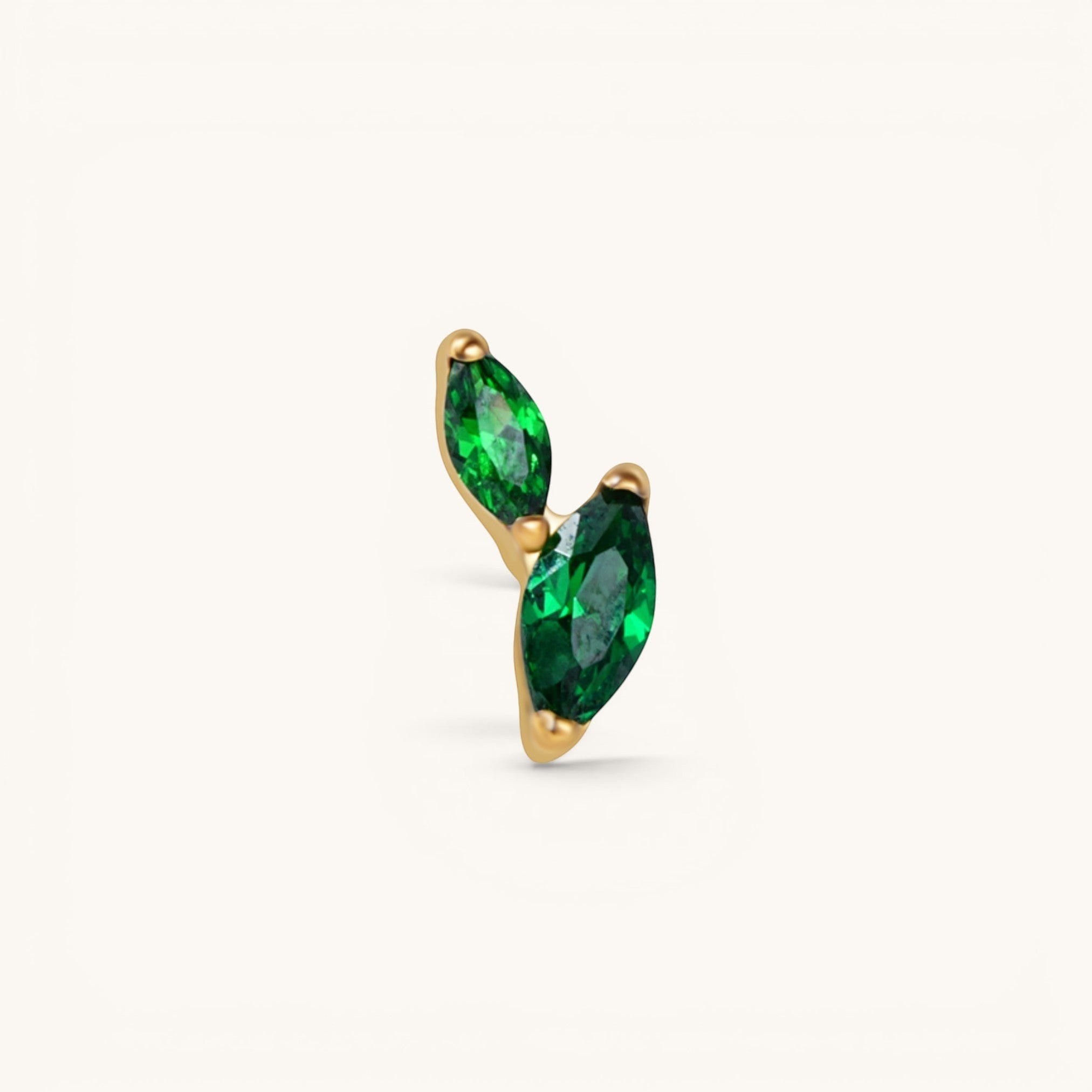 Nadare Co. Sage threadless piercing jewelry with two marquise-cut emerald green cubic zirconia stones in gold plating.