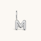 Nadare Co. silver-toned bubble initial charm in the shape of the letter M with a rounded, puffed design.