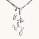 Nadare Co. silver chain necklace with a customizable clasp and various charms including a crystal, letter, and pearl.