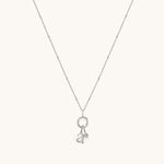 Nadare Co. silver necklace featuring a delicate chain with a circular charm, a lowercase letter a, and a birthstone.