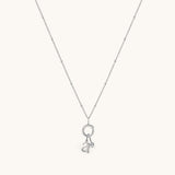 Nadare Co. silver necklace featuring a delicate chain with a circular charm, a lowercase letter a, and a birthstone.