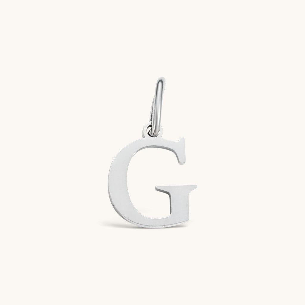 Nadare Co. silver-toned initial G charm with a clean serif font, crafted for everyday wear and necklace layering.