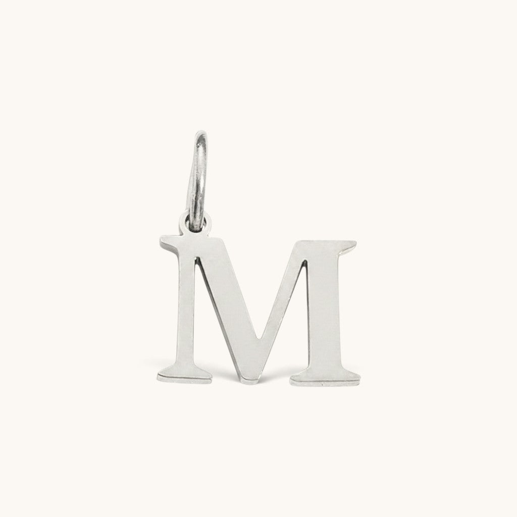 Nadare Co. silver-tone stainless steel letter M initial charm with a classic serif font design.