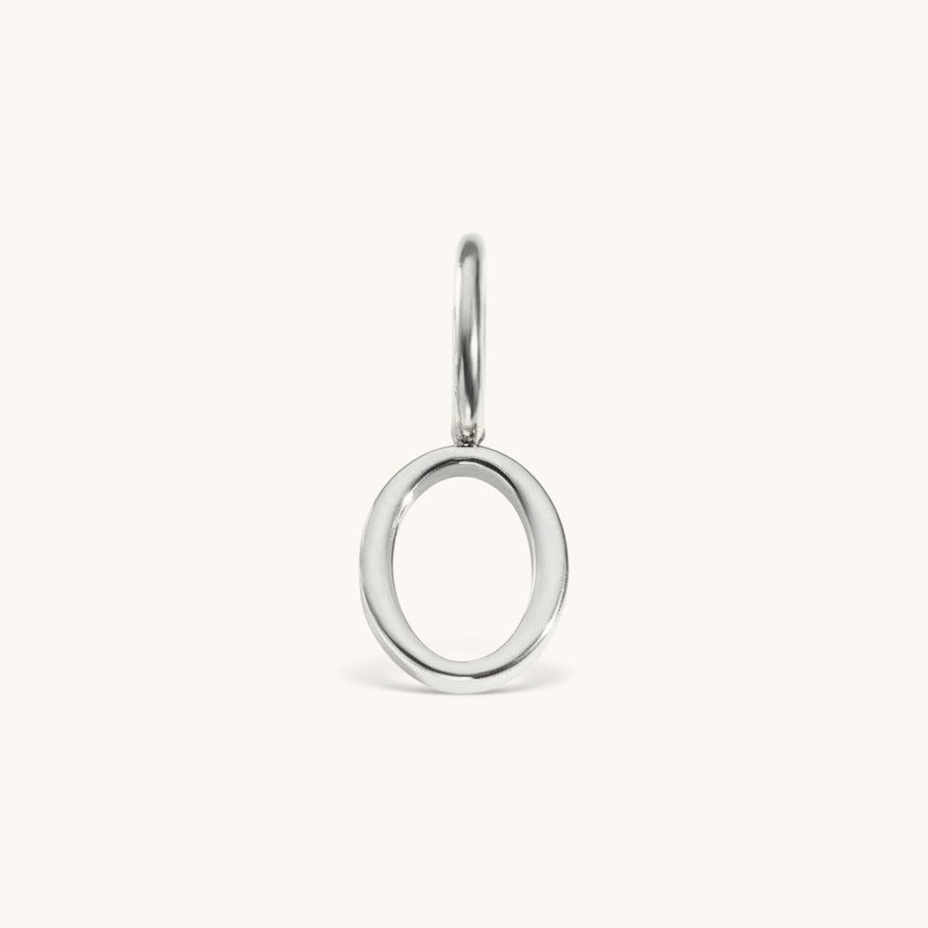 Nadare Co. silver-toned number zero charm made of stainless steel with a minimalist circular design.