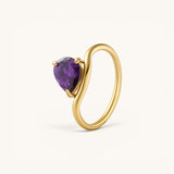 Nadare Co. Vela Birthstone Ring featuring a purple trillion-cut stone on a gold-plated stainless steel open band.