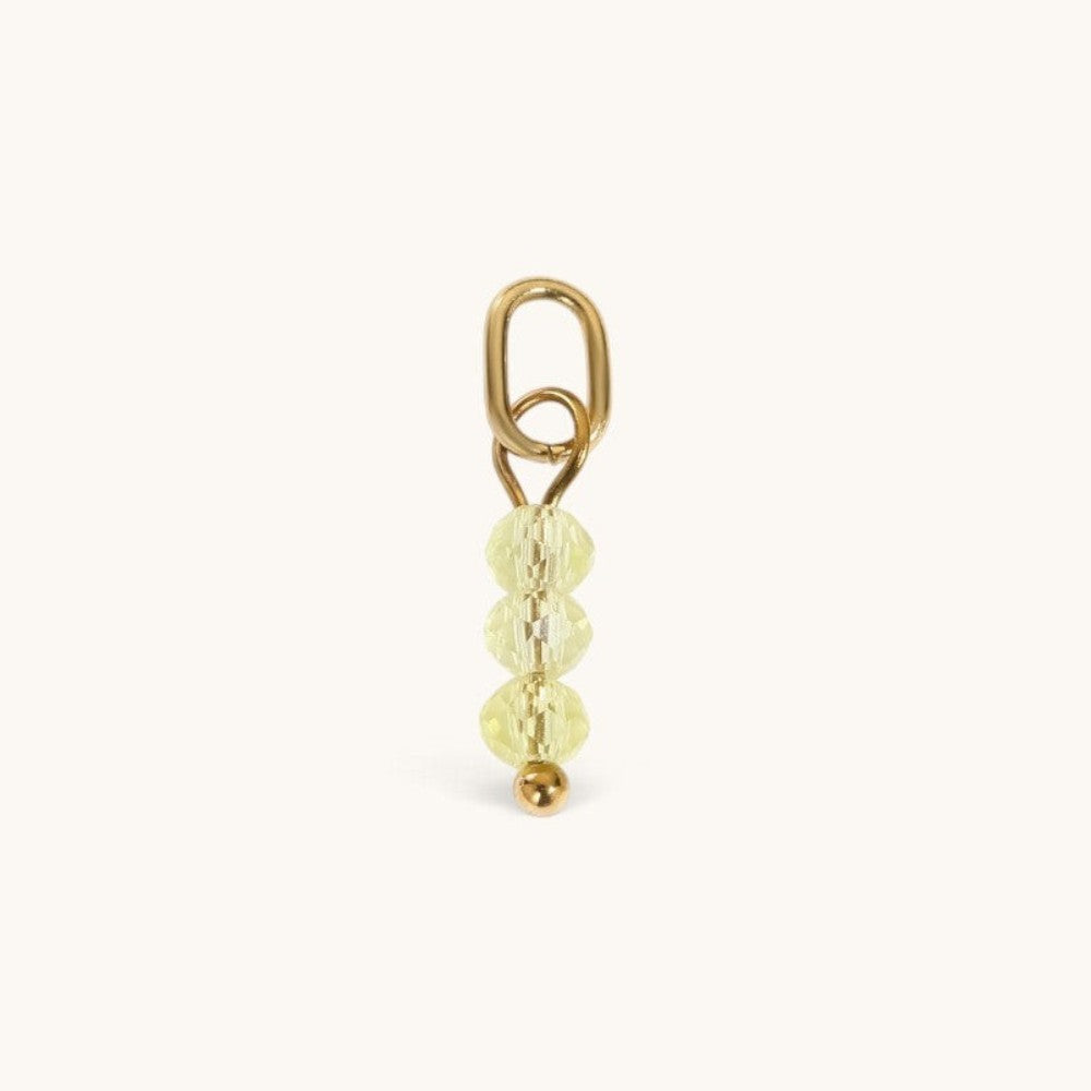 Nadare Co. birth month bead charm featuring three faceted pale yellow beads and a gold jump ring for necklaces.