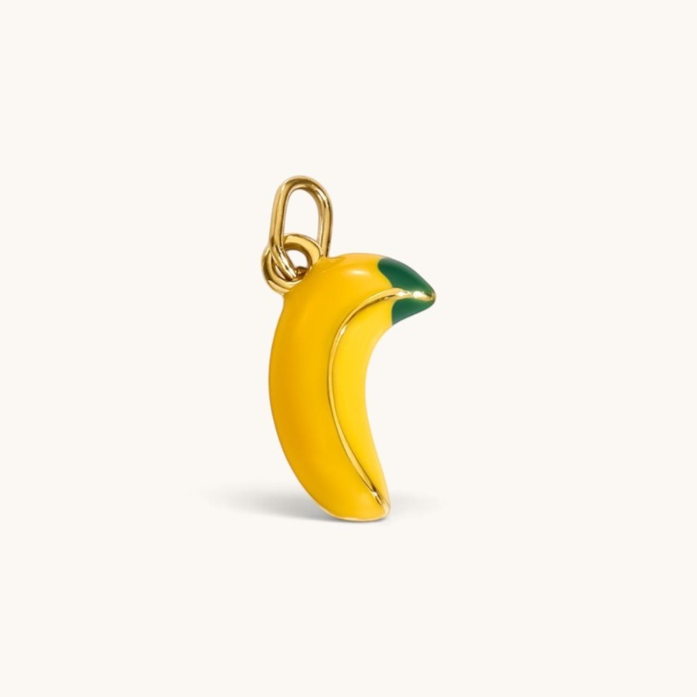 Nadare Co. banana charm in bright yellow enamel with green detailing and polished gold accents for necklace stacking.